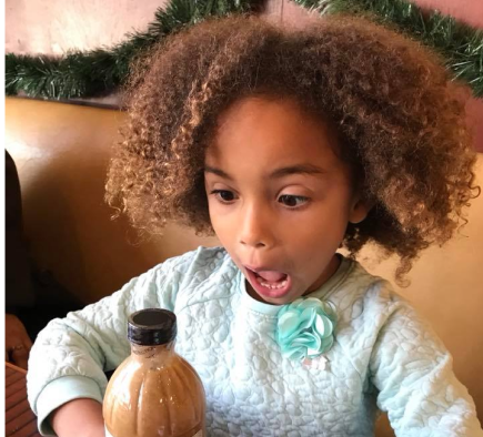 A girl with our salad dressing bottle